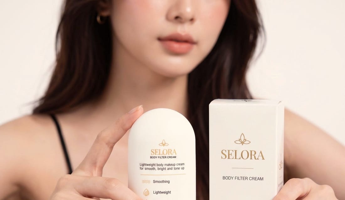 Người mẫu cầm tuýp và hộp Selora Body Filter Cream